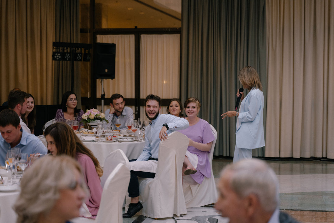 Candid wedding reception scene with guests seated at a decorated dining table