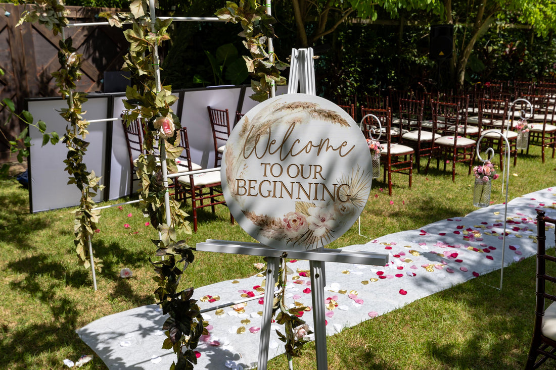 Personalized welcome easel sign on the aisle at an outdoor garden wedding