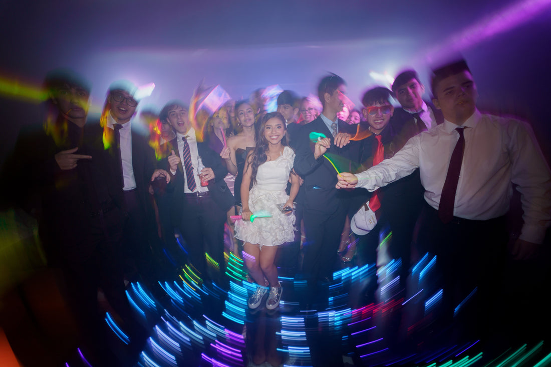 Group of party guests with glowing light trails at a nighttime celebration