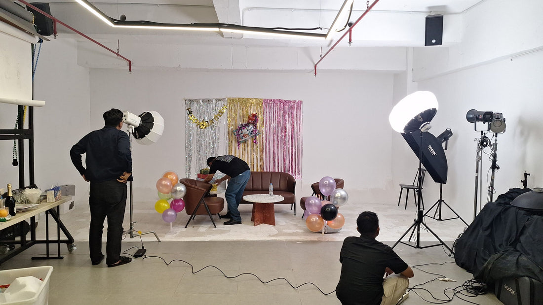 Crew adjusting a fringe photo backdrop and lighting before a party photoshoot