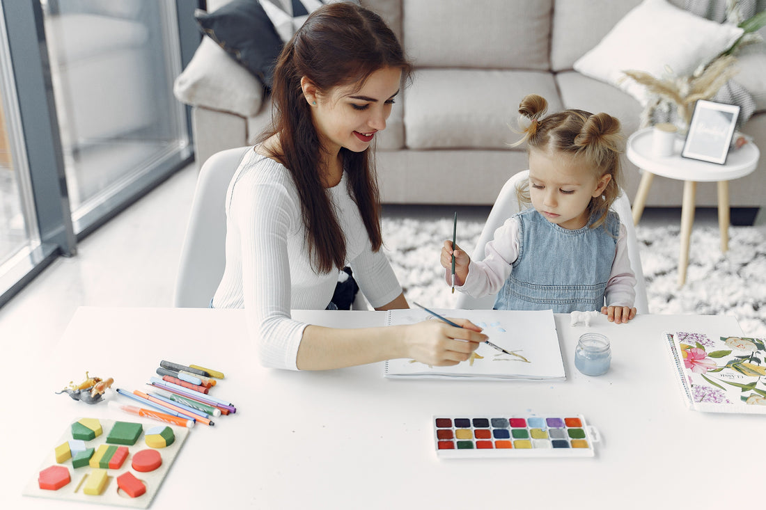Parent and child doing a colorful craft activity together at a bright home table