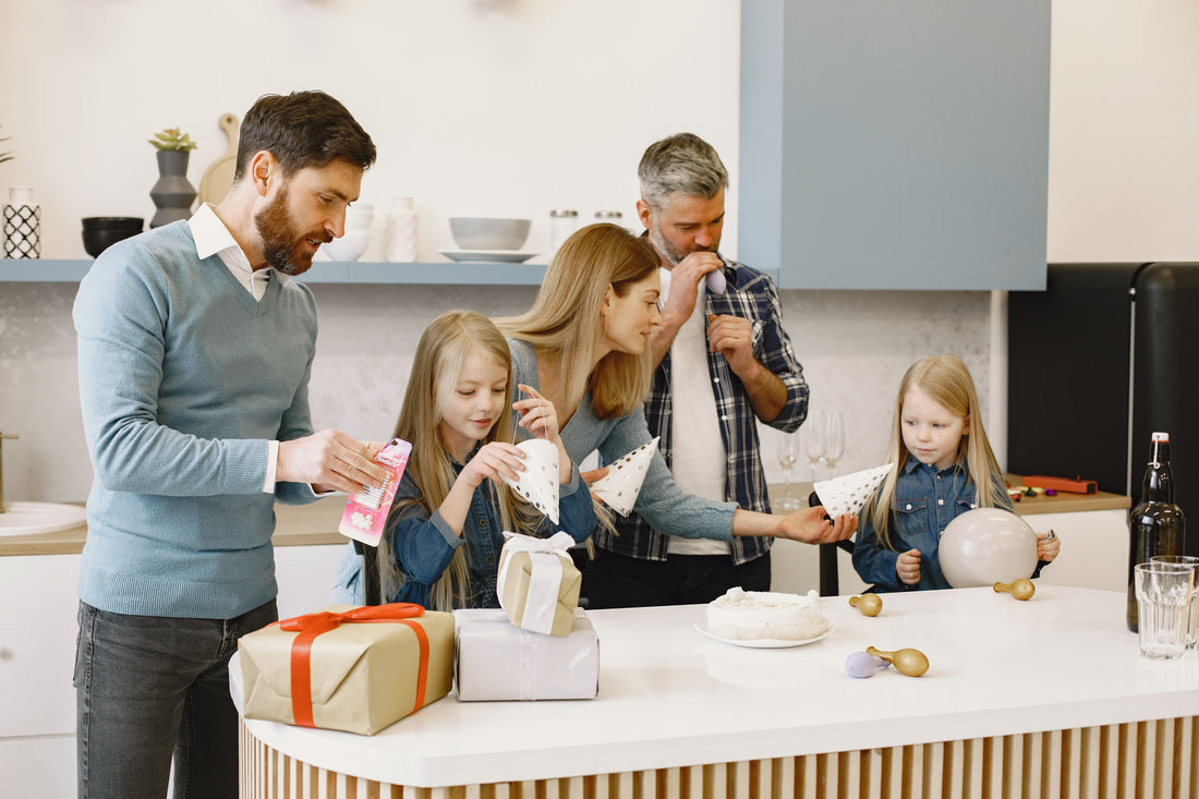 Family gathered around a kitchen island sorting party favor items and gifts before a birthday celebration