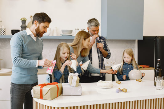 Family gathered around a kitchen island sorting party favor items and gifts before a birthday celebration