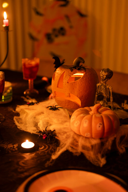Halloween tablescape with candlelight, a carved pumpkin and warm ambient light