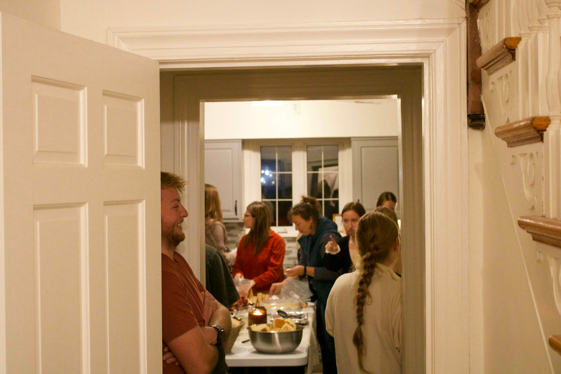 Friends gathering in a warmly lit home during a housewarming party